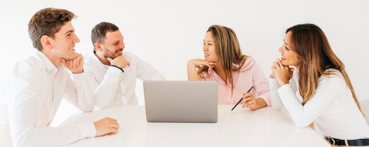 Colegas discutiendo y riendo en la oficina sobre ejercicios para desarrollar la creatividad