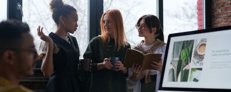 Estudiantes en la universidad discutiendo las ventajas de estudiar una maestría presencial