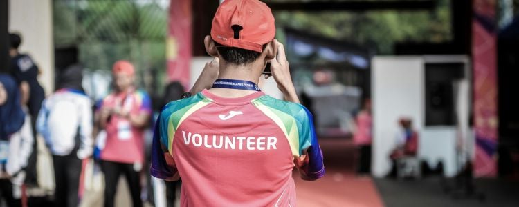 Joven siendo voluntario para ganar experiencia laboral en un evento