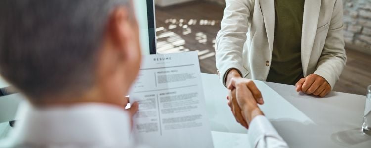 Hombre con su currículum siendo contratado tras tener éxito académico en UNID