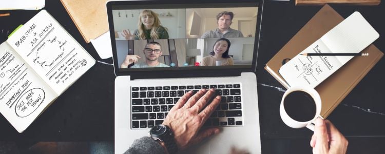 Persona trabajando en reuniones virtuales con sus compañeros