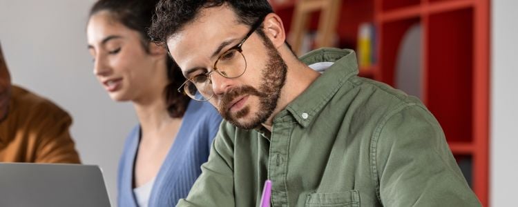 Hombre estudiando y buscando el balance entre el aprendizaje, el rendimiento académico y su salud mental