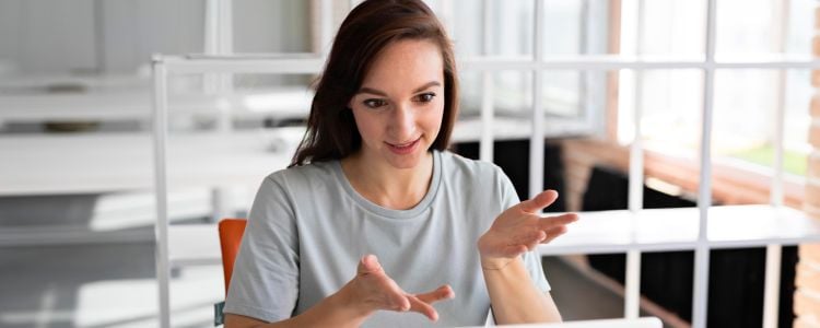 Mujer explicando algo frente a una laptop sobre el futuro de la educación universitaria
