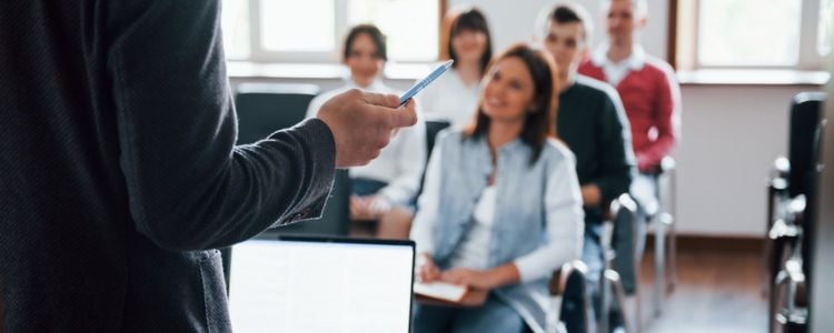 Alumnos escuchando al profesor en el regreso a clases con la nueva educación presencial
